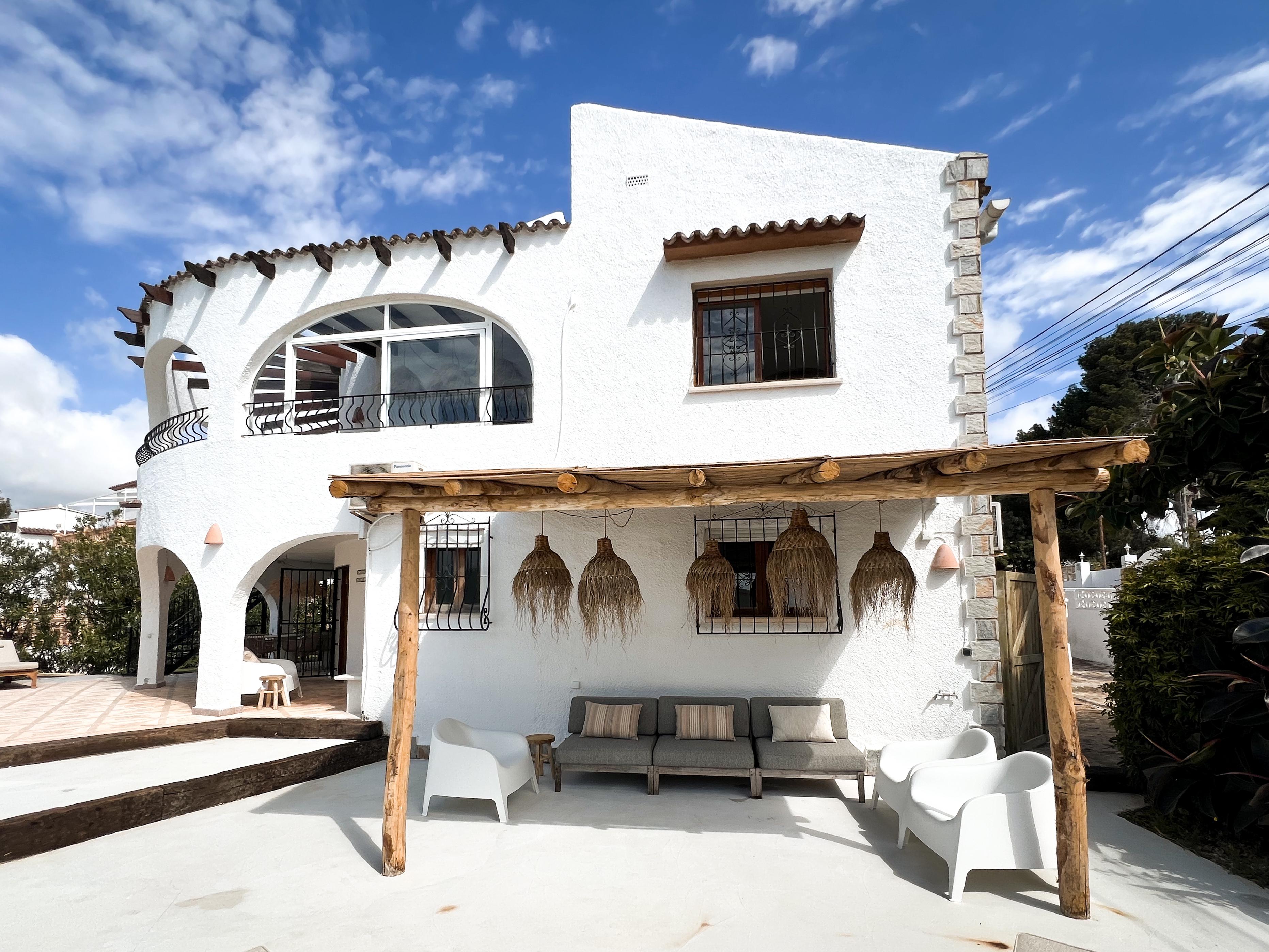 Vooraanzicht villa met sfeervolle pergola en lounge set